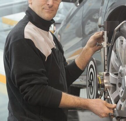 Motorcycle Maintenance - Man in Black Jacket Standing Beside Black Car