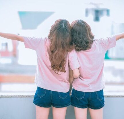 Eco-Friendly Living - Two Girls Spreading Arms Together While Kneeling