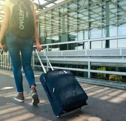 Travel - Woman Walking on Pathway While Strolling Luggage