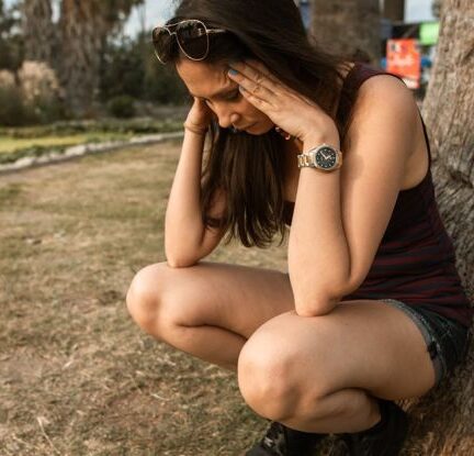 Stress - Photo of a Woman Crouching while Her Hands are on Her Head