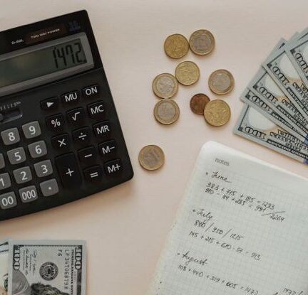 Budgeting - Black Calculator beside Coins and Notebook